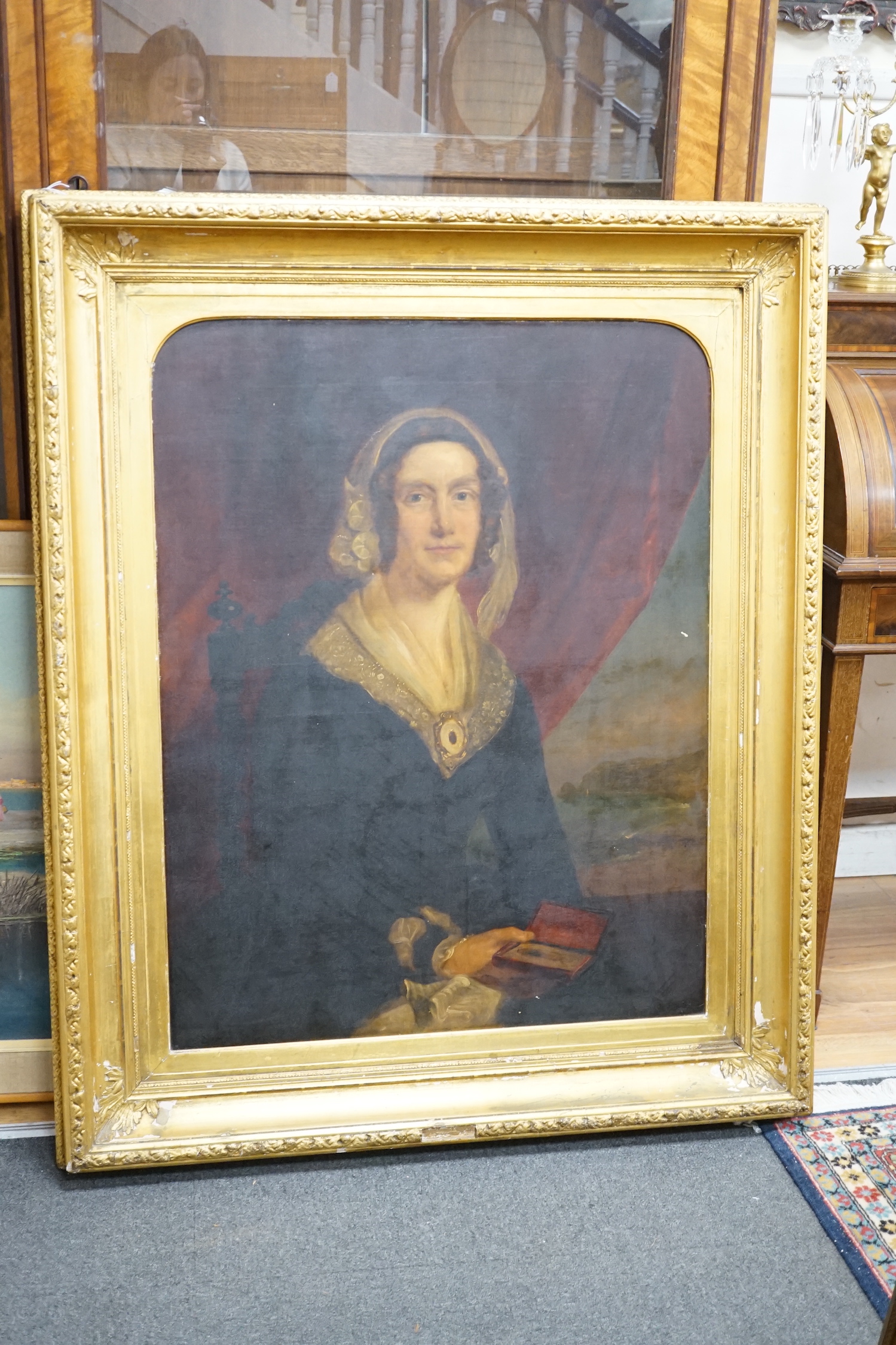 19th century English School, oil on canvas, Half length portrait of a lady holding a daguerreotype, 90 x 70cm